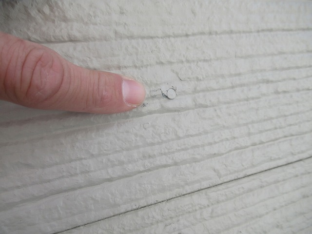 甲府市でサイディングボードの釘頭が劣化し、外壁から出てきている様子