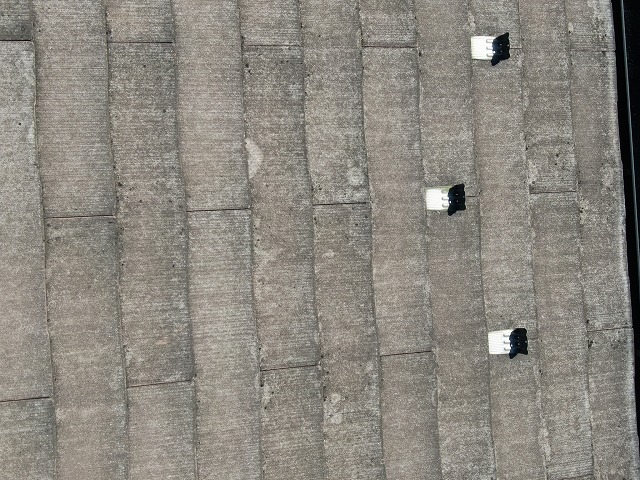 甲府市でスレート（コロニアル）屋根の調査で色あせ・雨垂れ跡を確認する様子