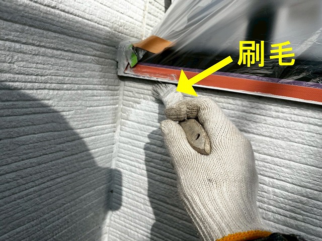 甲府市でサイディング外壁にシーラーで塗装する様子（刷毛使用）
