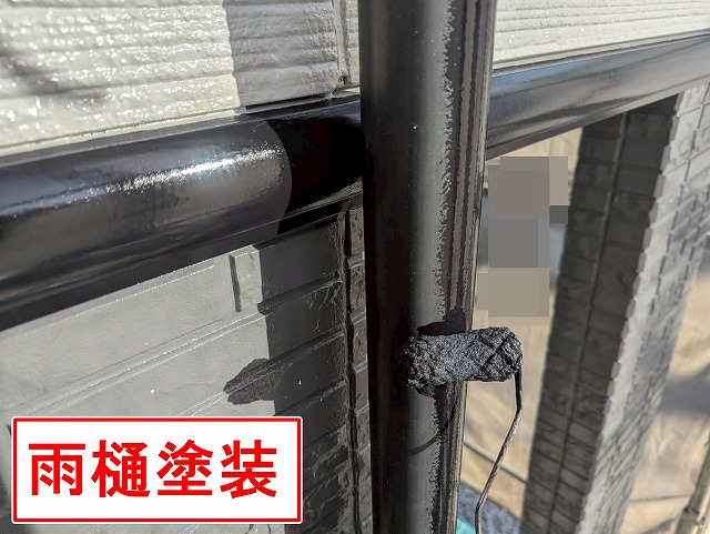 甲府市で雨樋（竪樋・エルボ）にケレン・目粗し・無機塗装を行う様子