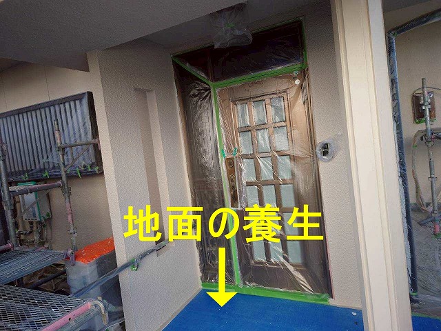 笛吹市で外壁塗装の際に付帯部（玄関扉・床）に養生をかける様子