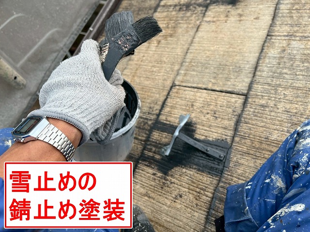 中巨摩郡昭和町でスレート屋根塗装時に雪止めの錆止め塗装を行う様子