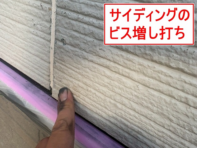 甲府市で外壁塗装前にサイディングボードの反った部分にビス増し打ち作業を行う様子