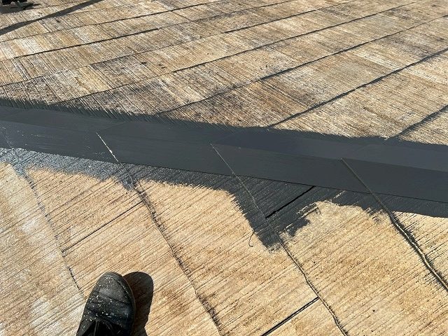 中巨摩郡昭和町でスレート屋根塗装時に板金の錆止め塗装を行う様子