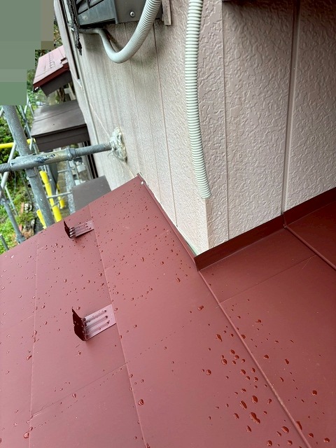 都留市で外壁と下屋根の継ぎ目に雨押え板金を設置する様子