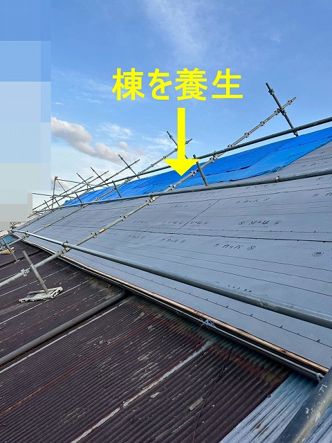 南アルプス市で屋根葺き替えの際に棟に雨養生をかける様子