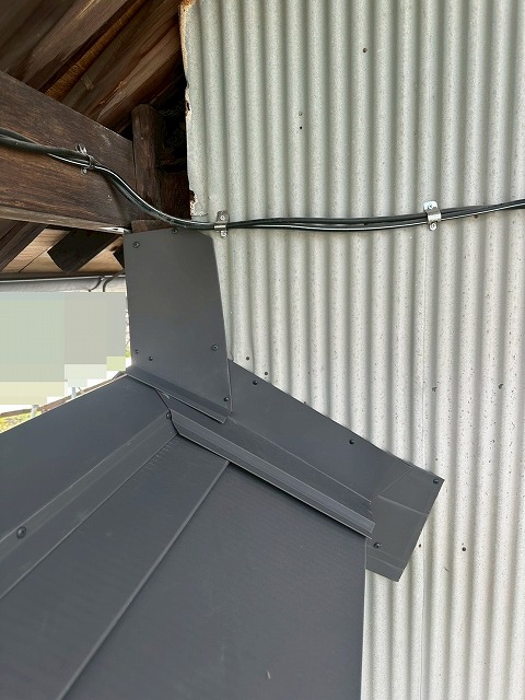 南アルプス市で下屋根の屋根葺き替え工事の際に水切り板金を設置する様子
