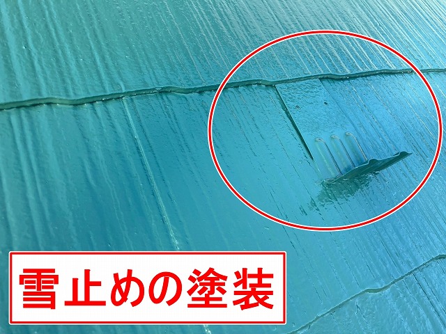 甲府市でコロニアル屋根（下屋根）の雪止めを塗装する様子